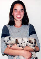 Stacy Rivera holding blue and red Queensland Heeler puppies.